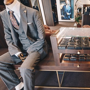 Manekin w eleganckim garniturze siedzi w sklepie