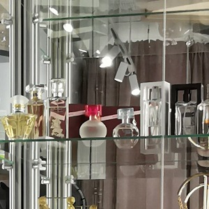 perfumy w sklepie umieszczone w szklanej gablocie sklepowej